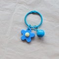 Handmade light blue knitted flower keychain with round bell and matching metal ring - Blue