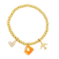 Détail du bracelet perlé avec charms avion doré, tasse à café orange et pendentif cœur - Orange