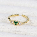 Close-up of 18K gold plated ring featuring three green emerald zircons on textured fabric - Three Green Gemstones Open Ring (款式13)
