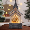 Dettaglio di una lanterna a forma di chiesa con presepe dettagliato e luci a LED calde - Stile Presepe