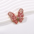 Elegante spilla a farfalla placcata oro con strass rosa e cristallo verde centrale - Rosa