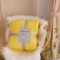 Yellow thick coral fleece blanket with herringbone pattern folded on a gold chair - Bright Yellow