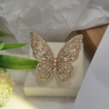 Close-up of golden butterfly open ring with sparkling cubic zirconia on floral background - Gold White Zircon