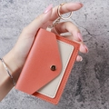 Mini accordion card holder with orange and beige leather, gold keychain, and snap closure - Orange