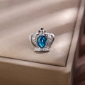 Dettaglio spilla corona argento con gemma blu a forma di pera e piccoli strass lucidi - Base Argento Pietra Blu