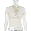 Dettaglio del top bianco in pizzo con scollo a V, decorazione a fiocco e vestibilità slim - S / Bianco Sporco