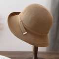 Detailed texture of hand-woven straw hat with elegant golden metal buckle accent - Khaki