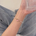 Primer plano de pulsera de perlas con colgante de corazón de melocotón rosa - Pulsera