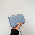 Detail of light blue V-quilted leather bag with golden chain strap and metal clasp closure - Blue