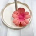 Tropical pink frangipani flower hair claw clip displayed on a white ceramic stand - Pink (Rubber Paint Lucky Flower)
