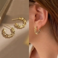 Detail view and model wearing golden textured hoop earrings in a minimalist style - Gold Textured C-Shape Style (E2189 Gold) / 925 Silver Needle / Gold