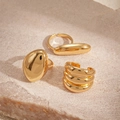 Vista detallada de tres anillos metálicos dorados minimalistas en superficie de piedra - Juego de 3 Piezas Dorado
