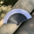Classical gradient fan with white leaf and black hollowed out wooden ribs on stone - Hollow Fireworks Black White