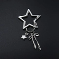 Silberner Stern Schlüsselanhänger mit kleinem Stern und Schleifenanhänger auf Schwarz - Silber Sternschnalle