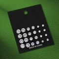 Detail view of 12 pairs of sparkling zircon stud earrings in various sizes on a black display card - Round Zirconia Style (S3637)
