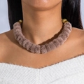 Detalle de una gargantilla de piel sintética marrón con toques dorados en una modelo - Leopardo Marrón