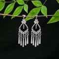 Detailed close-up of ethnic silver tassel earrings with hollow floral design on a branch - E4990-2 (Long Tassel)