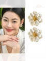 Details von perlmuttweißen Blumenohrringen mit gelbem Staubblatt und Tragebeispiel - 3D Gänseblümchen-Ohrstecker / Stahlnadel-Eco-Weiß-Gold