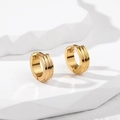 Close-up of gold stainless steel huggie earrings with three parallel engraved lines - Gold Striped
