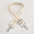 Close-up of adjustable beige nylon strap with golden arrow pattern and silver hardware - White Gold Thread + Silver Buckle
