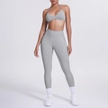 Dettaglio del reggiseno sportivo grigio e leggings yoga a vita alta su modella - Grigio chiaro