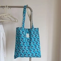 Detail van blauw-wit bloemenpatroon op vintage katoenen canvas draagtas met label - Blauw Blauw Bloemenpatroon
