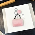 Dettaglio del portachiavi a borsa in peluche rosa con pompon e anello in metallo lucido - Confezione in busta singola OPP / Rosa