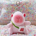 Pink Capybara plush keychain featuring a green strap bag with a red fortune character - Pink Red Fortune + Silver Clip