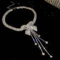 Macro shot of sparkling silver butterfly tassel necklace with pavé crystal fringe details - Bowknot Style Tassel / Silver