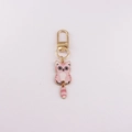 Detailed close-up of a pink cartoon cat keychain with golden metal clasp on white background - Pink Striped Cat
