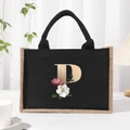 Black canvas tote bag featuring floral letter P print and natural jute trim detail - Bronze Floral Letter P