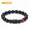 Detail of Cancer zodiac bracelet with black onyx beads and engraved crab symbol stone - Cancer