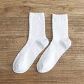 Classic white crew socks with vertical ribbed texture on a natural wooden background - White