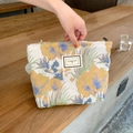 Detail einer floralen Brokat-Kosmetiktasche mit Metallreißverschluss und Etikett - 3D-Ölgemälde