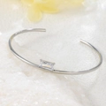 Vista macro di un bracciale rigido in acciaio al titanio argento con zircone rettangolare - Bracciale in Zirconia Quadrata / Argento