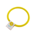 Detailed close-up of a high-elasticity yellow fabric hair tie with a floral tag motif - Yellow