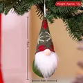 Knitted green Christmas gnome ornament with snowflake pattern hanging on a festive tree - Style L