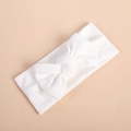 Detailed texture of white knitted ribbed headband with a large minimalist bow design - White