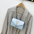Fashionable woven crossbody bag in light blue with gold chain strap and tassel detail - Blue