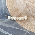 Elegant gold pearl barrette with multi-sized white pearls on a stylish summer straw hat - Gold Staggered Pearl Bobby Pin