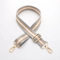 Nahaufnahme des gestreiften Leinen-Trageriemens mit goldenen Metallhaken auf Weiß - Gun Black Hardware / A4 Streifen Schimmer
