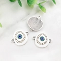 Silver devil's eye charms with blue turquoise stones on white marble background - Bright Silver White Evil Eye-14594