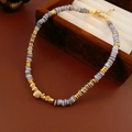 Detailaufnahme der Perlenkette mit graublauen Steinscheiben und goldfarbenen Akzenten - Gold/Grau