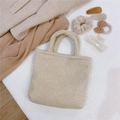 Close-up of cream teddy faux fur handbag with cozy winter texture and matching accessories - Beige