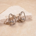Close-up of silver metal twisted sphere earrings on a textured beige stone background - Silver (Silver Pin)