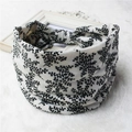 Detail of wide elastic headband featuring black and white leaf print on soft fabric texture - 7-Black White Floral