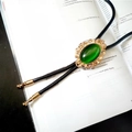 Detail of vintage crown bolo tie with green stone on braided leather cord and gold tips - NO.007 (Gold with Green Stone)
