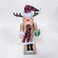 Wooden reindeer nutcracker with red plaid hat and scarf holding a green gift box - Animal Reindeer