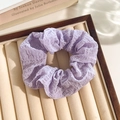 Sierlijke lila kanten scrunchie met bubbeltextuur op een fluwelen displaystandaard - Paarse Seersucker