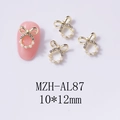 Dettaglio charm fiocco per unghie 10x12mm con strass luminosi e perle bianche - Stile Fiocco con Perla Oro (AL87)